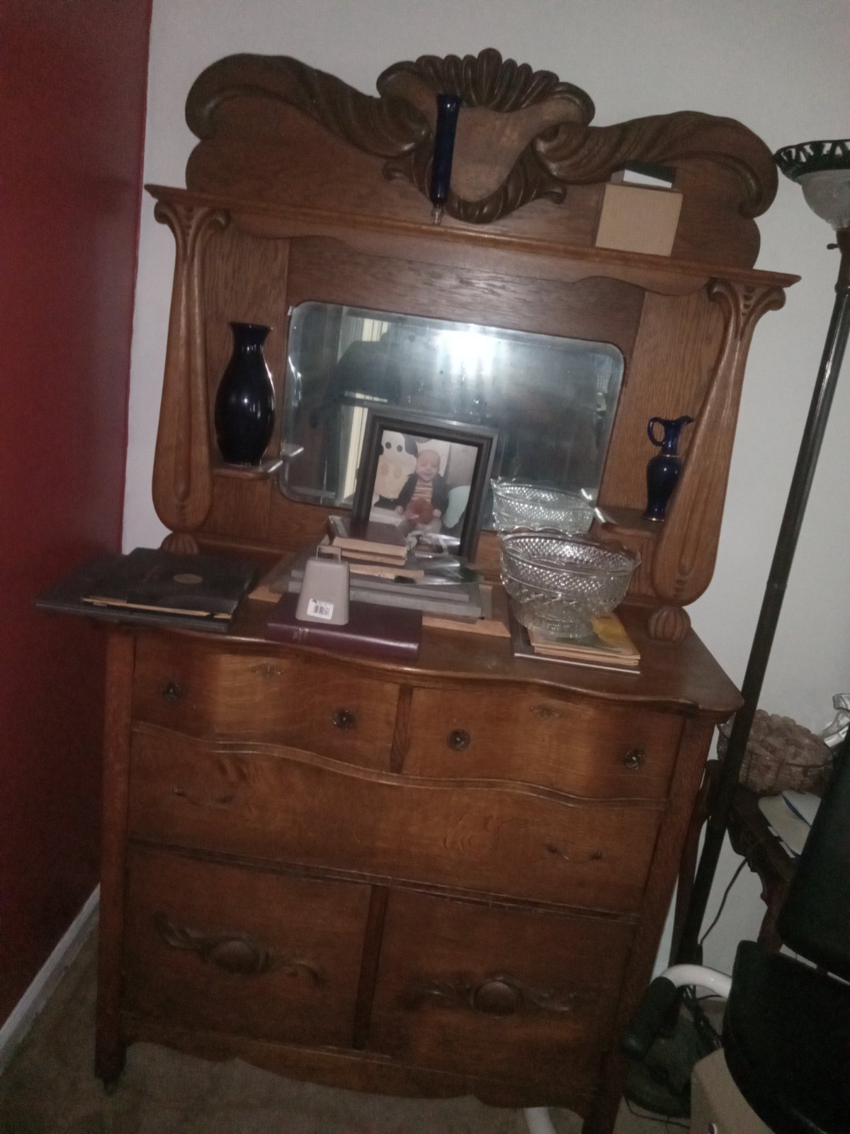 Vintage oak wood sideboard with a tall mirrored hutch topper featuring ornate carvings and serpentine drawers.