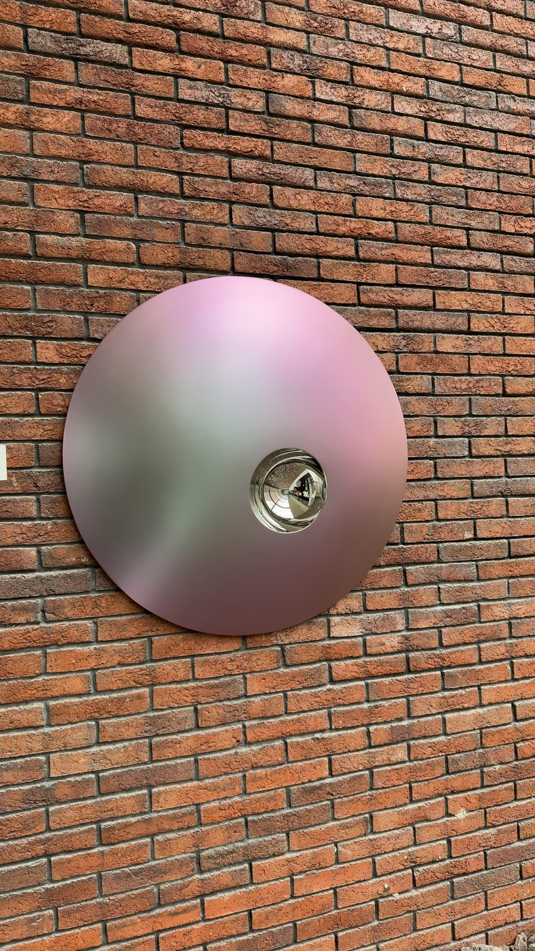 Contemporary stainless steel wall sculpture by Ronald Westerhuis featuring a matte iridescent dome with a mirrored concave void. - view 1