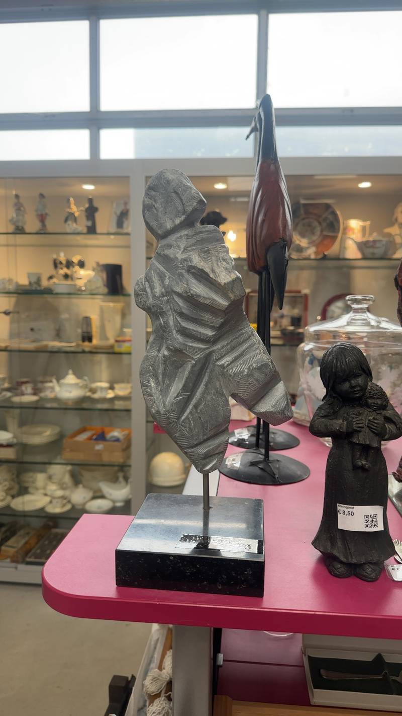 Mid-century modern abstract stone sculpture resembling a cloaked figure on a black marble base.
