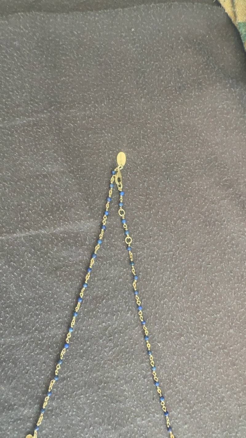ORUS brand necklace featuring small blue lapis lazuli beads wire-wrapped in gold-toned chain with a branded oval tag near the clasp. - view 1