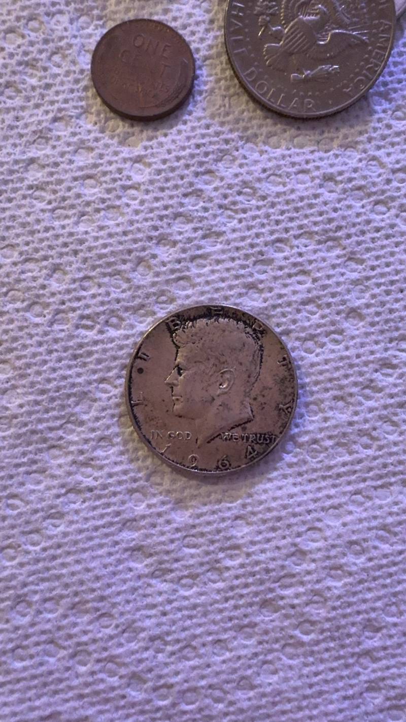 Obverse and reverse views of a 1964 silver Kennedy Half Dollar showing circulated wear and dark toning. - view 1