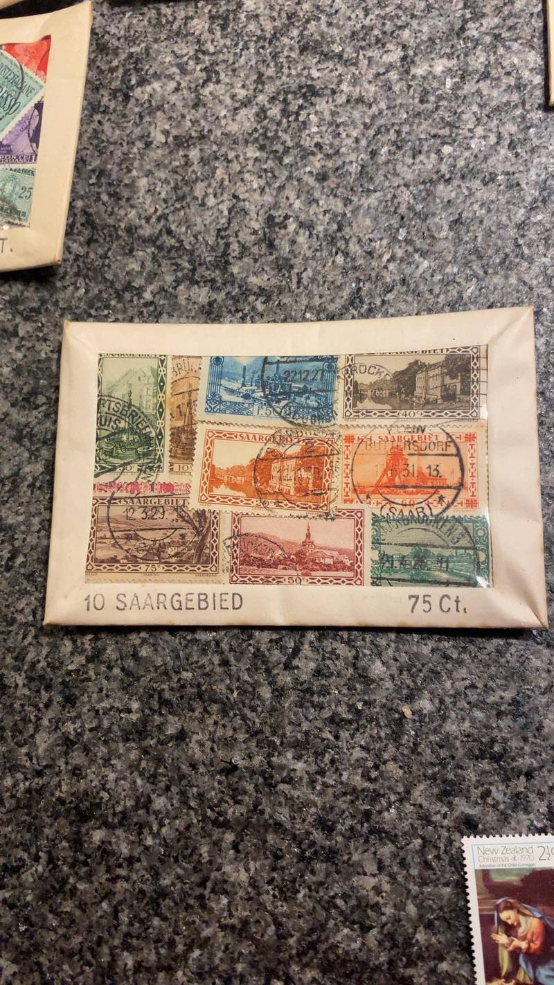 A group of nine used 1920s Saar Basin postage stamps mounted on a paper card titled '10 SAARGEBIED 75 Ct.' showing various landscapes.