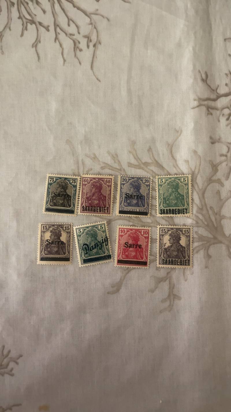 A collection of vintage stamps including German Germania overprints for Sarre and Danzig, Hong Kong Queen Elizabeth II issues, and Ajman Olympics. - view 1
