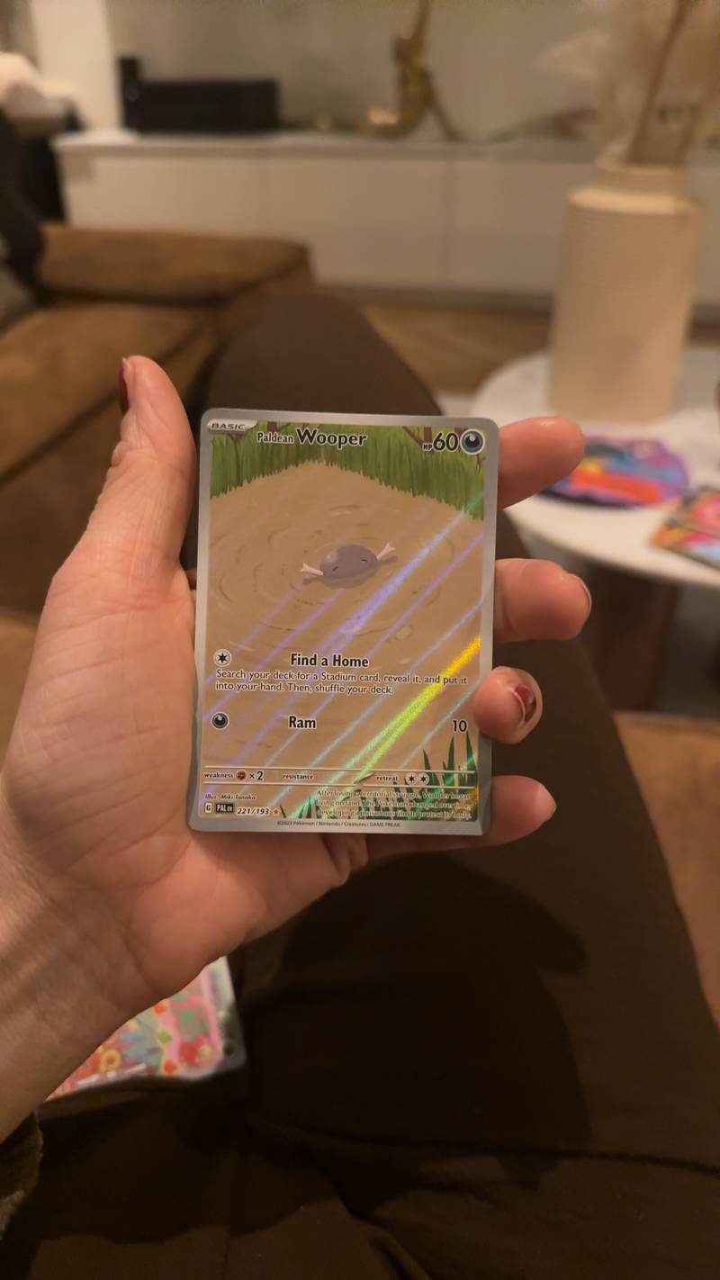 Pokémon Paldean Wooper Special Illustration Rare card from Paldean Fates set, held in hand, showing holofoil effect.