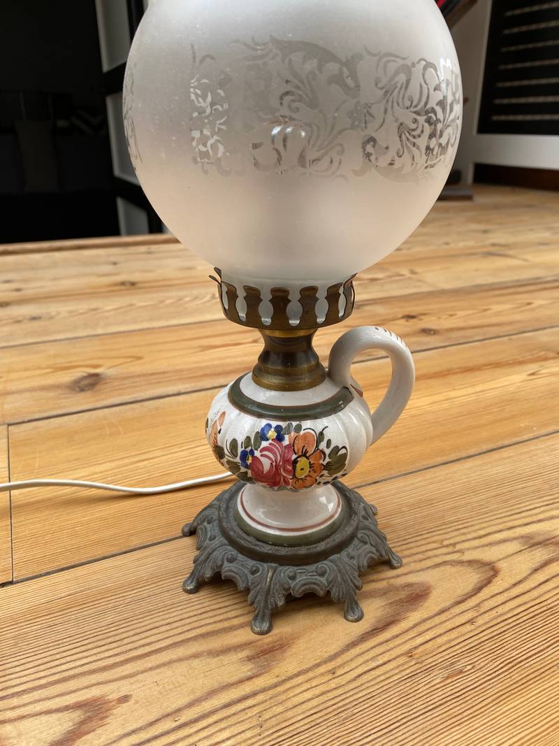 Electric table lamp with a hand-painted ceramic base, frosted etched glass globe, and clear chimney on a wooden floor. - view 1