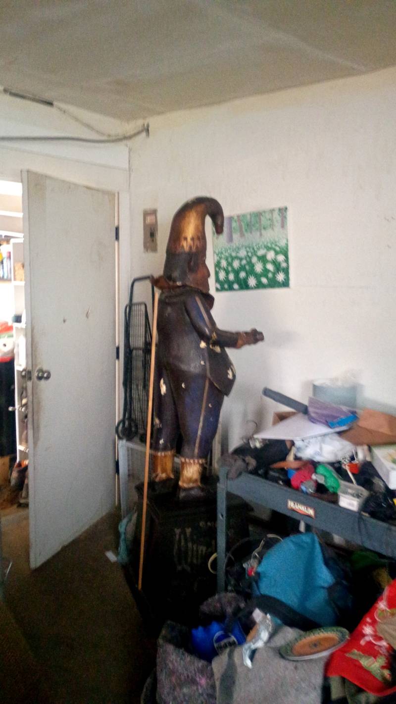 Large carved wooden figure of Punch with a tall hat and significant paint loss on the belly. - view 1