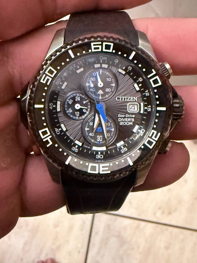 Citizen Promaster Eco-Drive Aqualand chronograph watch with black dial, blue hands, and integrated rubber strap.