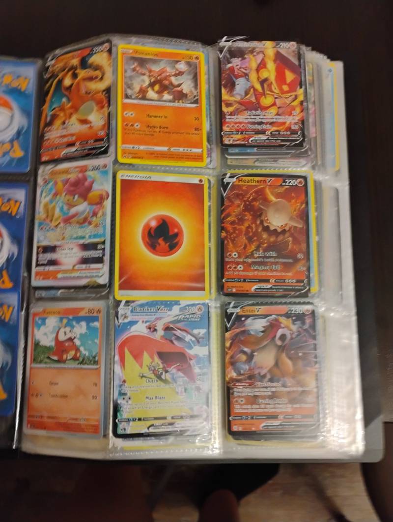 Binder page containing nine modern Fire-type Pokémon trading cards including Charizard V, Blaziken VMAX, and Entei V