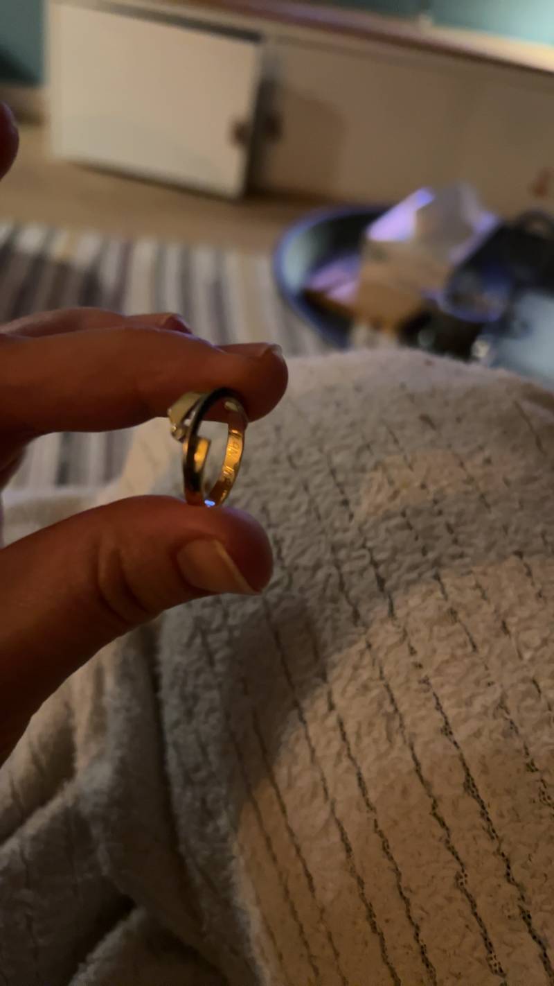 Close-up of a gold-toned ring with a round, illusion-set gemstone on a finger - view 1