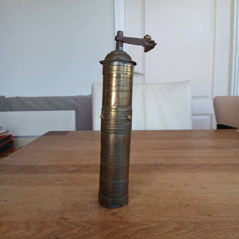 Vintage brass Zassenhaus cylindrical coffee mill with folding iron handle and stamped lion hallmarks on a wooden table. - view 1