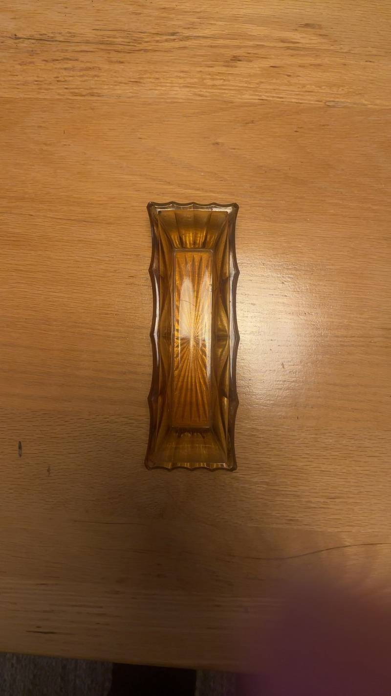 Rectangular amber pressed glass dish with starburst pattern on a wooden surface. - view 1