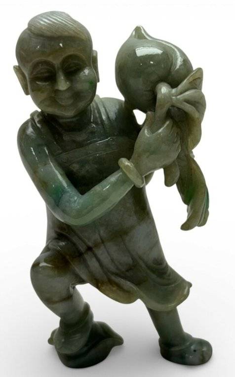 Green and grey jadeite carving of a Chinese boy holding a large peach, featuring moss-in-snow color patterns. - view 1