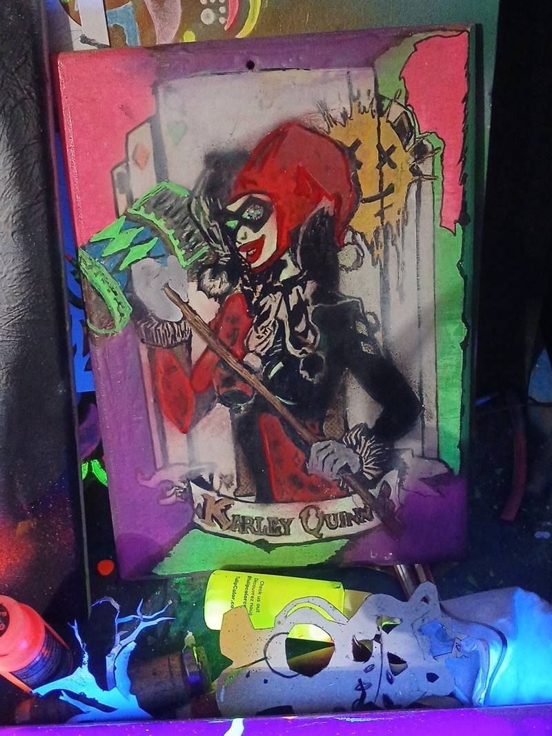 Carved and painted wooden panel depicting Harley Quinn with glowing UV paint and pyrographic details
