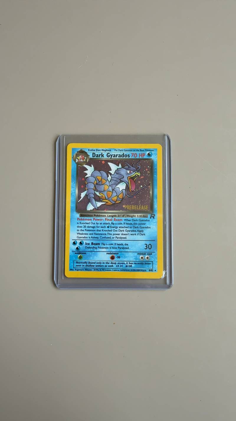 A holographic Dark Gyarados Pokémon card from the Team Rocket set with a gold Prerelease stamp, housed in a plastic top-loader. - view 1