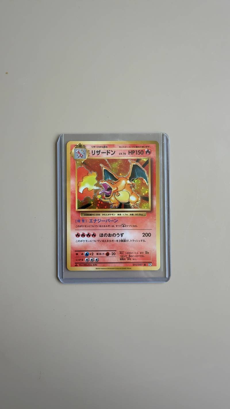 A Japanese 1st Edition Charizard Pokémon card from the 2016 20th Anniversary CP6 set, featuring original Mitsuhiro Arita artwork in a top-loader. - view 1