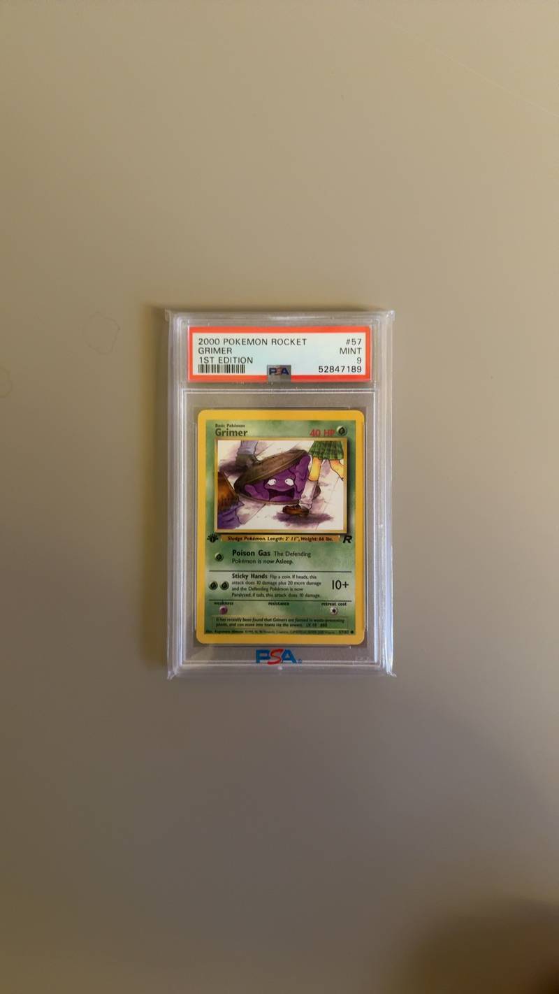 PSA 9 Mint graded 2000 Pokémon Team Rocket Grimer 1st Edition card 57/82 in a protective plastic slab. - view 1