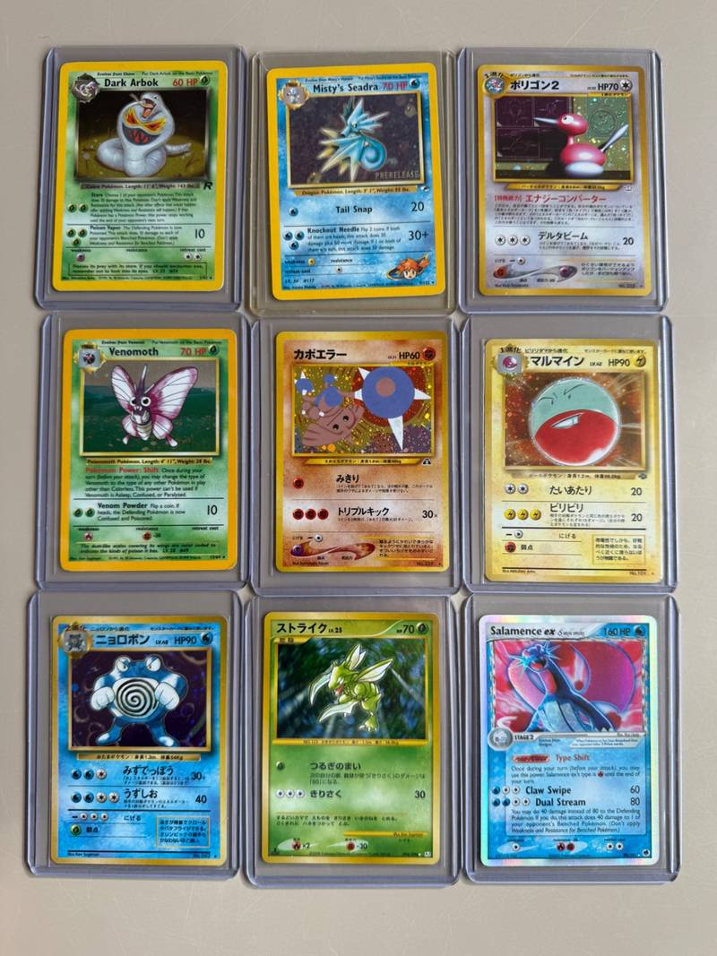 Nine vintage Pokemon holographic cards in top loaders including Salamence ex, Dark Arbok, and Japanese Neo cards - view 1
