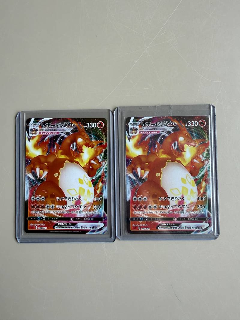 Two Japanese Charizard VMAX trading cards numbered 002/021 from the 2020 starter deck in protective holders - view 1